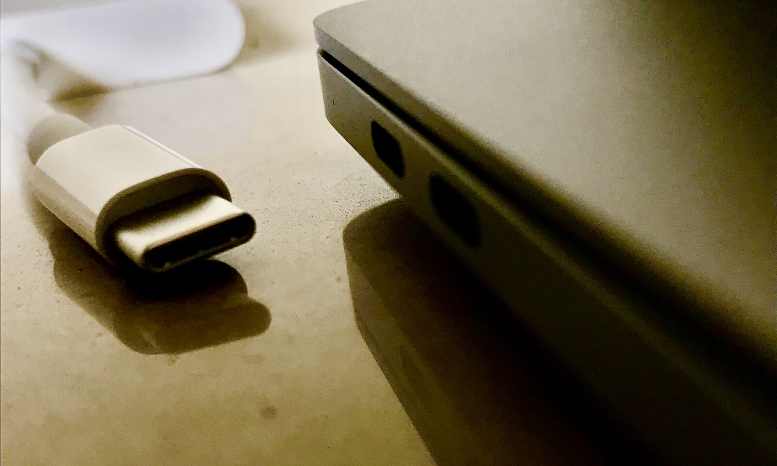 A USB-C / Thunderbolt cable next to a MacBook port