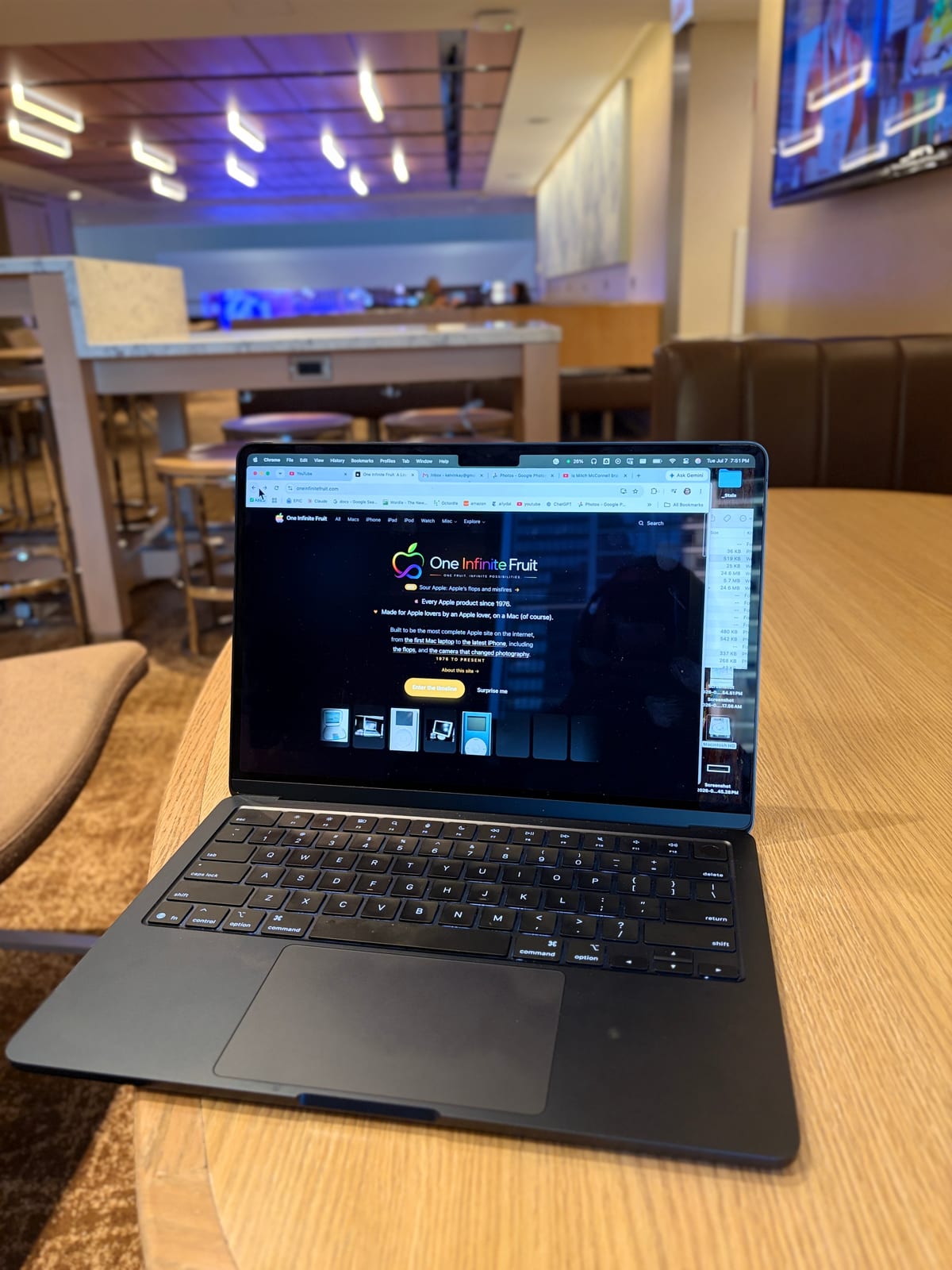 My MacBook Air open on a café table, One Infinite Fruit on the screen