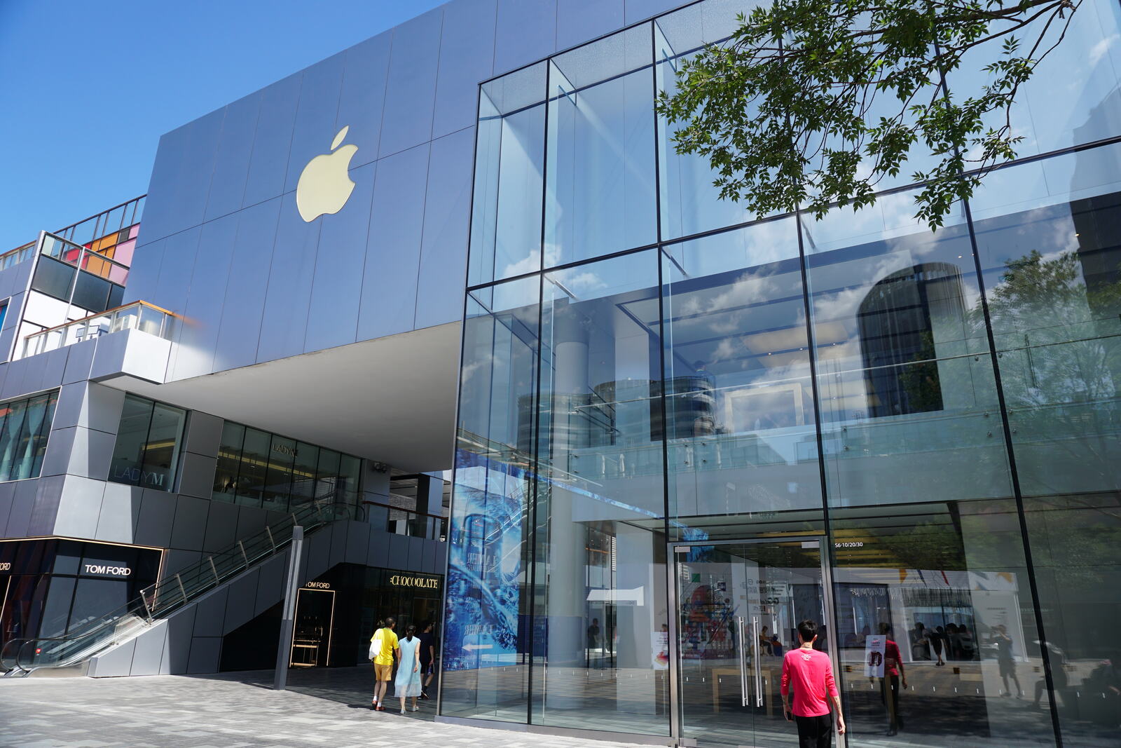 An all-glass store tucked beside the luxury names in a modern mall.