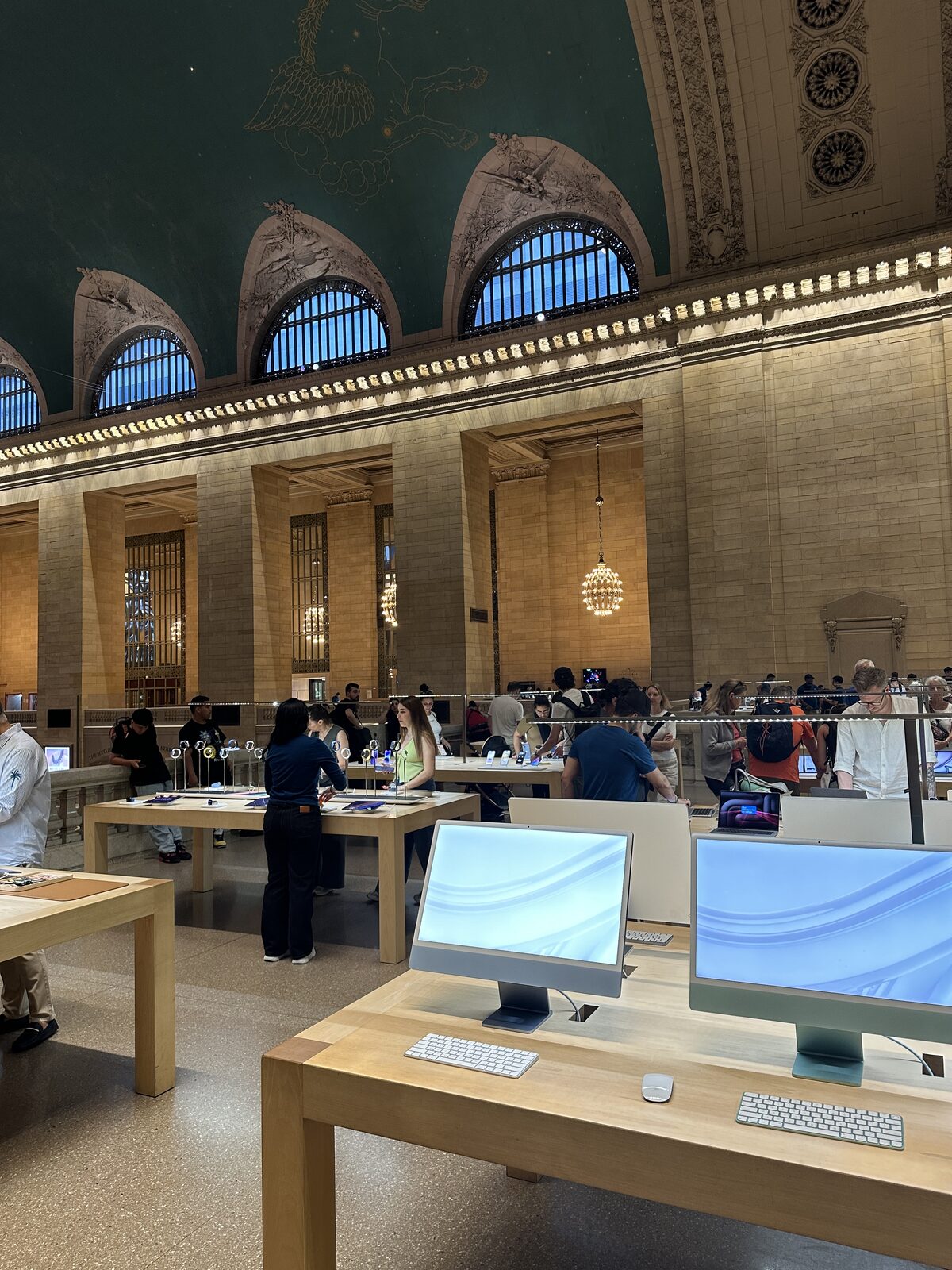 Tables on the concourse floor, the terminal’s great arched windows behind.