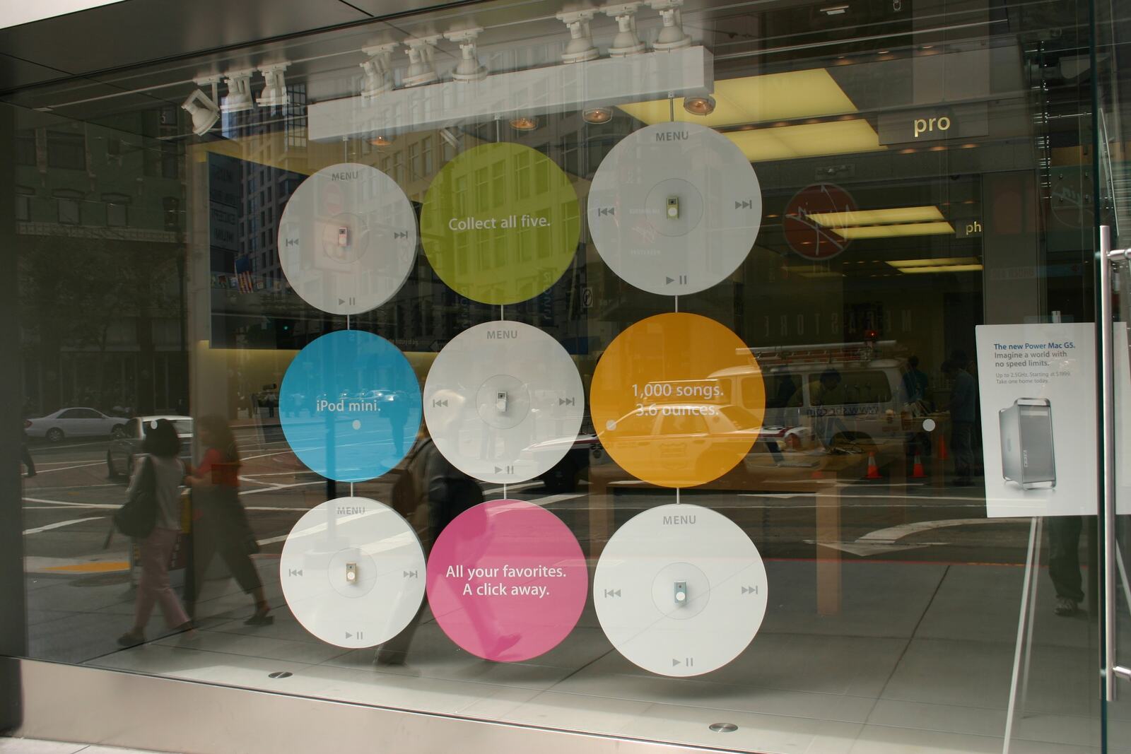 A store window in the iPod mini days: “Collect all five,” a thousand songs in your pocket.