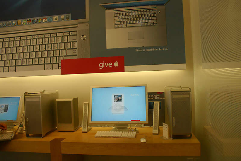 A (PRODUCT)RED promotion, Power Mac G5s and a Cinema Display on the table.
